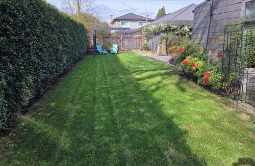 Hastings House | Modern home on a corner lot with large lawn area and patio with hot tub.