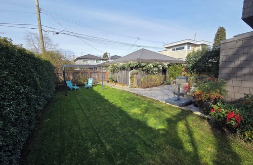 Hastings House | Modern home on a corner lot with large lawn area and patio with hot tub.