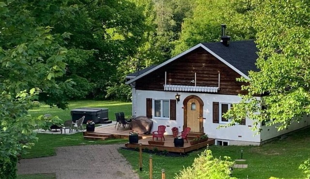 Chalet Valcartier with spa on the side of the river.